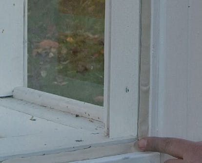 Kitt slätas ut i ruta i orangeri Kitt slätas ut med ett finger i ruta i orangeri